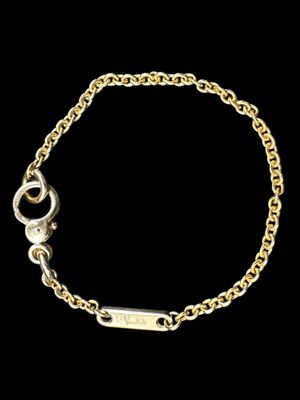 a gold chain bracelet with a small bar on it
