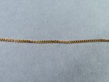 a close up of a gold chain on a blue surface
