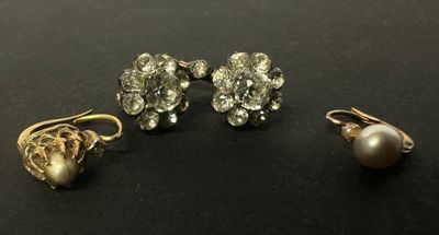 trois paires de boucles d'oreilles et une perle sur un fond noir