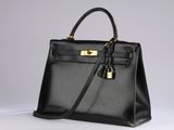 a black leather handbag on a white surface