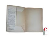 an open book with a page in it on a white surface
