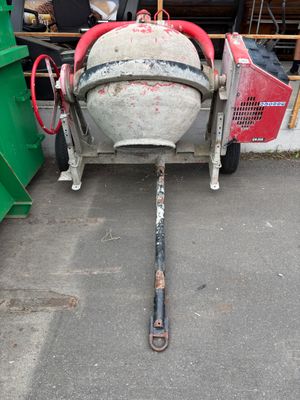 a cement mixer that is sitting on the ground