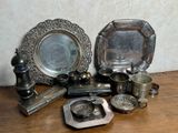 a lot of silver items sitting on a wooden table