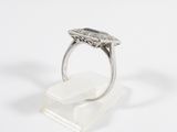 a close up of a silver ring on a clear stand