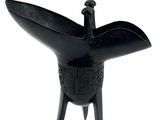 an image of a black sculpture of a bird on a stand