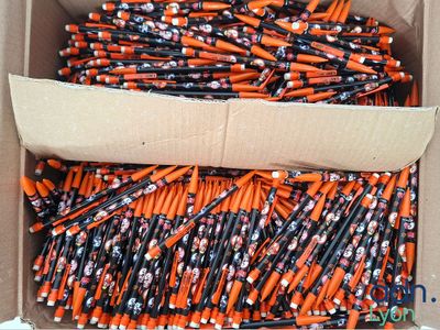 une boîte en carton remplie d'une multitude de crayons orange et noirs