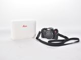 a white box with a camera on it and a black strap
