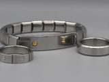 deux bracelets en acier inoxydable et une bague posés sur une surface blanche