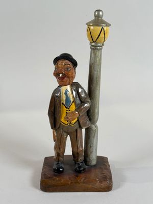 a figurine of a man smoking a cigarette next to a lamp post