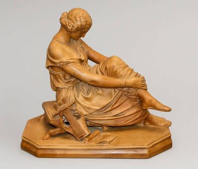 statue représentant une femme assise sur un tabouret, un livre à la main