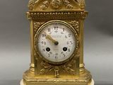 a gold clock sitting on top of a white table