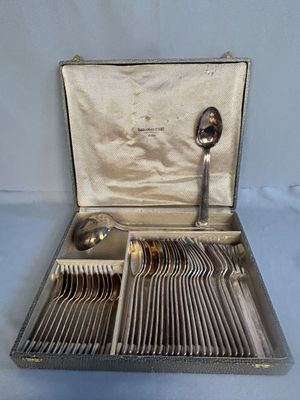 a silver case with silverware in it on a blue surface