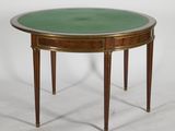 a round table with a green glass top and wooden legs