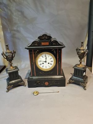 a small clock sitting on a table next to other items