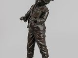 a bronze statue of a man holding a baseball bat on a base
