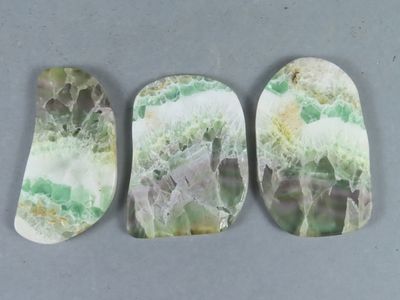 trois morceaux de marbre vert et blanc posés sur une table
