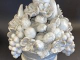 a white vase with a bunch of fruit in it