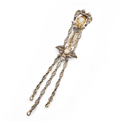 a close up of a gold and white broochle on a white background