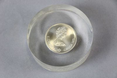 a small glass bowl with a coin inside of it