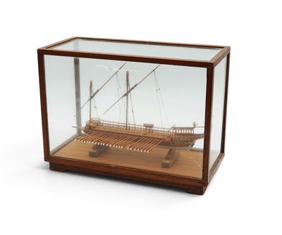 une maquette en bois d'un bateau exposée dans une vitrine