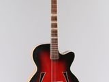 une guitare rouge et noire accrochée à un mur blanc