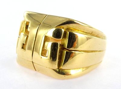yellow gold ring with black stones on a white surface