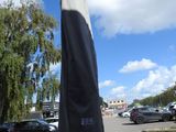 un grand parapluie posé au milieu d'un parking