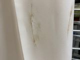 a dirty curtain hanging on a rack in a bathroom