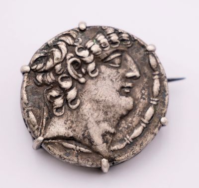an old silver coin with a woman ' s head on top of it