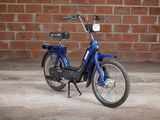 a blue bike parked in front of a brick wall