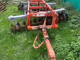 an image of a tractor with a plow attachment in the grass