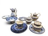 several pieces of blue and white pottery are arranged on a white surface