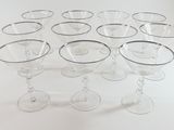nine wine glasses arranged in a circle on a white surface