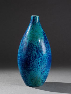 un vase bleu et vert posé sur une table