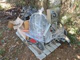 a pile of junk sitting on a pallet in the woods