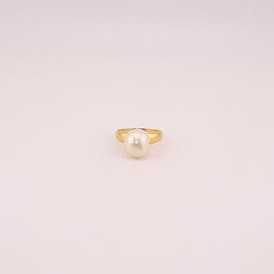 une bague en or avec une perle au centre