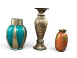 three vases sitting next to each other on a white surface