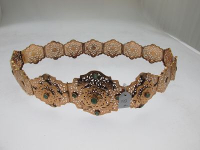 une image représentant un bracelet en or orné de pierres vertes sur un fond blanc