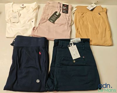 quatre paires de polos et de pantalons pour homme posées sur une table