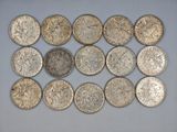 a group of silver coins sitting on top of a white surface