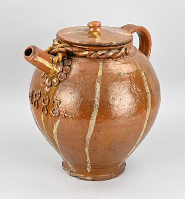 un vase marron muni d'une anse et d'un couvercle