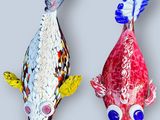 deux sculptures de poissons colorés sur une surface grise