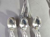 five spoons and two spoons sitting on a table