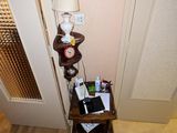 une petite table sur laquelle est posée une lampe, dans un coin de la pièce
