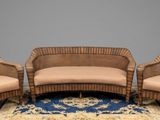 three wicker chairs and a couch on a rug