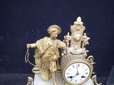 a gold clock with a statue of an angel on it