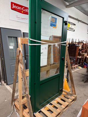 une palette en bois sur laquelle repose une porte verte dans un entrepôt