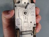 a hand holding a silver cell phone in it ' s left hand