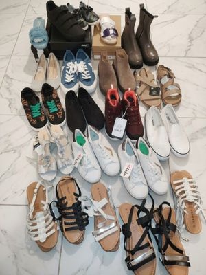 many pairs of shoes that are sitting on the floor