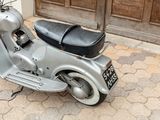 a motor scooter parked on the sidewalk in front of a door